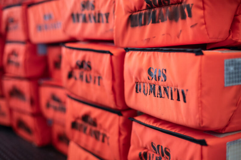 Gestapelte Rettungswesten mit Aufdruck SOS Humanity