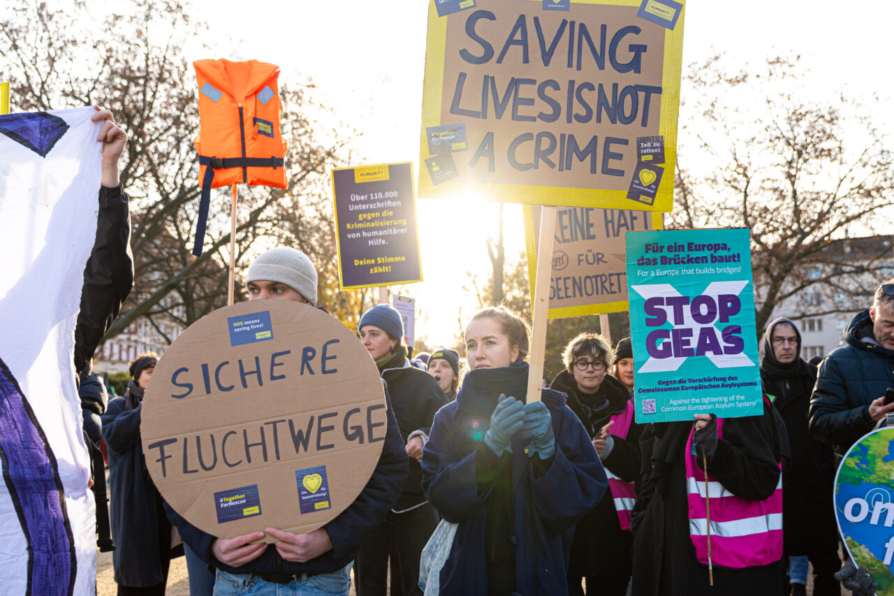 Foto einer Demonstration in Berlin, auf der viele Menschen Schilder halten für sichere Fluchtwege und die Seenotrettung