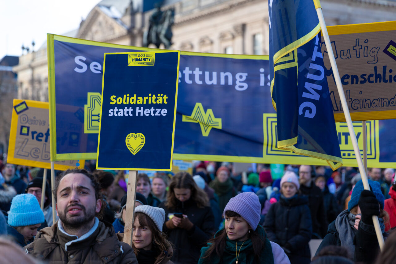 Demonstrant*innen halten ein Schild mit "Solidarität statt Hetze" bei einer Demo gegen die AFD.