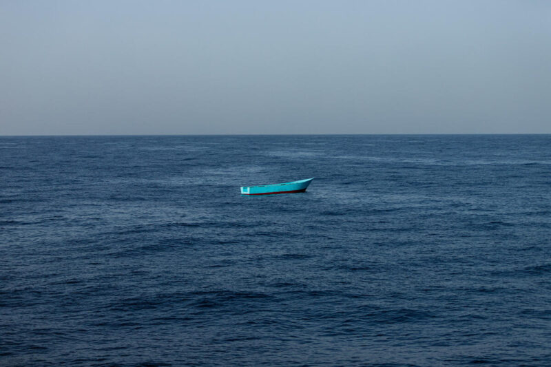 leeres kleines blaues Flüchtlingsboot inmitten eines Sturms auf dem zentralen Mittelmeer