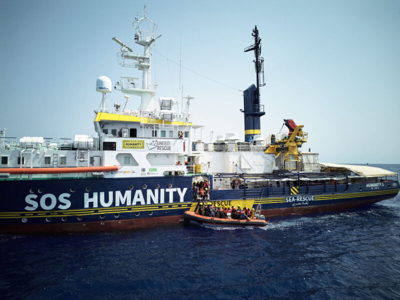 Dronenfoto der Humanity 1 und eines Rettungsboots mit Geretteten.